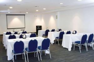 利马Radisson Hotel Decapolis Miraflores的一间会议室,配有白色的桌子和蓝色的椅子