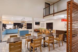 DahlgrenCountry Inn & Suites by Radisson, Dahlgren-King George, VA的用餐室以及带桌椅的厨房