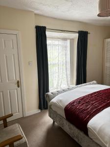 邓莱里Mulgrave Lodge的一间卧室设有一张床和一个窗口