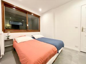 戛纳Le GALLIA 2 BEDROOM refait à neuf CENTER OF CANNES的一间卧室设有两张床,窗户配有电视。