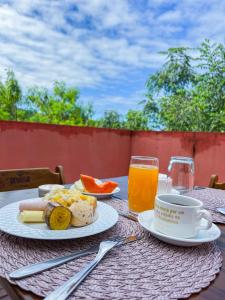 伦索伊斯Pousada Sempre Viva Lençóis的餐桌,上面放着一盘食物和一杯橙汁