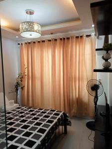 马尼拉Robinson manila birchtower的一间卧室配有大窗帘和吊灯
