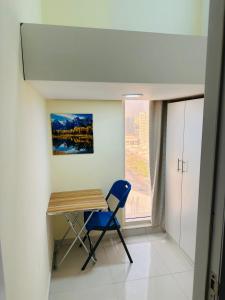 迪拜Private Room in beautiful Appartment的窗户客房内的一张桌子和一把椅子