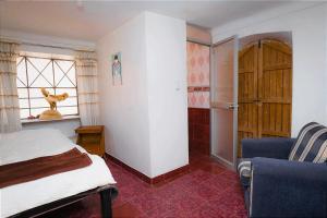 皮萨克Aguaymanto pisac hostel的一间卧室设有一张床、一个窗口和一把椅子