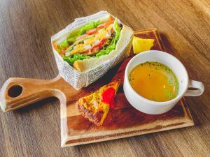 大阪UMEDAHOLIC HOTEL的三明治和木托盘上的汤