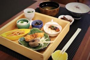 名古屋KOKO HOTEL Nagoya Sakae的装满餐桌食物的木托盘