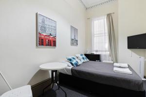 悉尼Falcon Lodge的一间小卧室,配有一张床和一张桌子