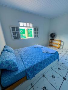 伦索伊斯Pousada Sempre Viva Lençóis的一间卧室配有一张带蓝色床单的床和一扇窗户。