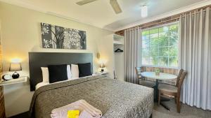 塔姆沃思金颗粒汽车旅馆的一间卧室配有一张床、一张桌子和一个窗户。