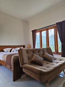 姆杜克梅德奥卡寄宿宾馆和商店的一间卧室配有沙发和一张带窗户的床。