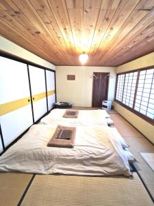 富士吉田市Mt Fuji Historical Oshi house hitsuki的配有窗户的客房内的一张大床