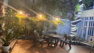 岘港CÁT TƯỜNG MOTEL的庭院配有桌椅和植物