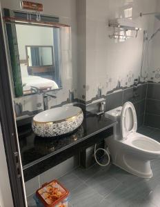 三岛县Khách Sạn Hùng Trang Hotel的一间带水槽、卫生间和镜子的浴室