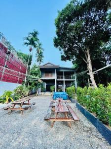 贡布HOLY VILLA 4rooms, 5beds, 6baths, 1KCH, 1LR riverside private villa的一组野餐桌在建筑前