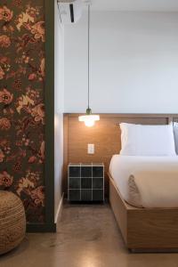 里诺Best Bet Motor Lodge的一间卧室配有一张床和一张带花卉壁纸的墙壁