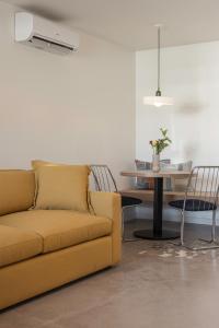 里诺Best Bet Motor Lodge的客厅配有黄色的沙发和桌子