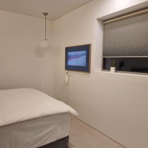 统营市Laon on 37的一间卧室配有一张床和一台平面电视