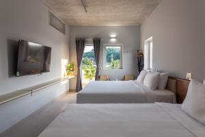 富国The Up Phu Quoc的配有窗户的酒店客房内的两张床