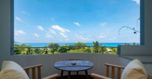 昂斯布瓦洛Seychelles的阳台配有桌子,享有海景。