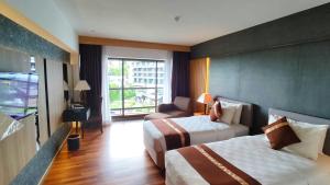 秾莎巴塔姆海景假日酒店的酒店客房设有两张床和窗户。