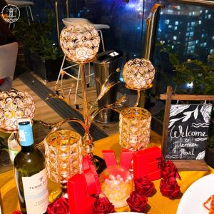头顿Premier Pearl Hotel Vung Tau的一张桌子,上面放着一瓶葡萄酒和红玫瑰