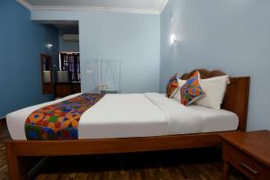 瓦加托FabHotel Prime 4D's Coast Resort的一间卧室配有一张白色大床和木架
