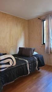 梅利佩乌科Cabaña Mirador del Valle的铺有木地板的客房内设有一间卧室和一张床。