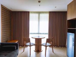 努沙杜瓦Pearl Nusa Dua Suite的客厅配有桌椅和窗户。