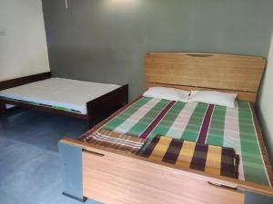 马纳尔Enoch Guest House的配有两张单人床的客房配有一张床和一张床垫