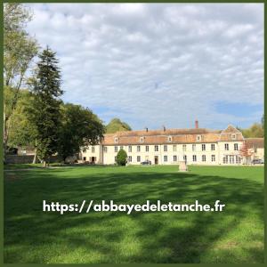 Abbaye de l'Etanche - 2 chambres d'hôtes - Un cadre naturel exceptionnel -的前面有大片草地的大建筑