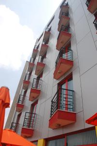 亚的斯亚贝巴Wassamar Hotel的一座高高的公寓楼,设有红色的阳台