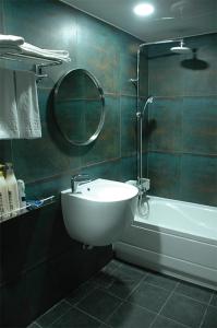 固城郡Prince hotel的一间带水槽、浴缸和镜子的浴室