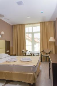 泽列诺格拉茨克伊丽莎酒店的一间卧室配有一张床,上面有两条毛巾