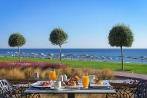 法里拉基净土Spa度假酒店的一张桌子,上面放着食物和橙汁,还有海洋
