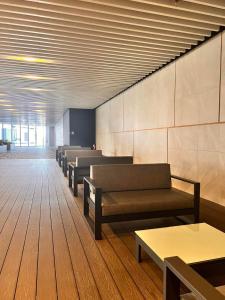 马尼拉Air Residences的一间设有一排长椅和桌子的等候室