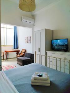 海法伊甸园酒店的一间带电视床的卧室和一间客厅