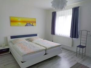 巴特法灵博斯特尔Ferienhaus Heide的卧室配有白色的床和窗户。