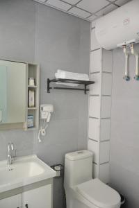 哈尔滨Hongge Hotel - Harbin Taiping Airport的白色的浴室设有卫生间和水槽。