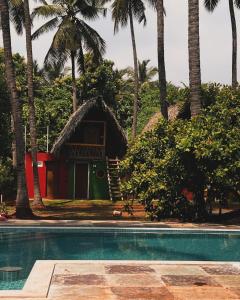 蓬蒂切里Nature Zone Resort的一个带游泳池和棕榈树的度假村