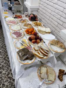 撒马尔罕Hotel Maroqanda的一张长桌,上面放着许多盘子的食物