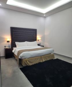 迪巴Mirage Bab Al Bahr Beach Resort的一间卧室配有一张大床和黑色床头板