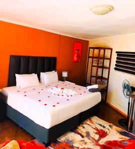 HekpoortAvela Lodge的一间卧室配有一张红色鲜花的大床
