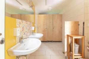 普雷德沃尔Glamping Mohorjev grunt的一间带两个盥洗盆和木制橱柜的浴室