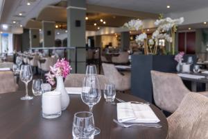 阿尔森弗莱彻罗兰德餐厅酒店的一张带酒杯和鲜花的木桌