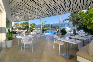 埃斯普霍斯福门特拉岛布兰科酒店的一间带桌椅的餐厅和一个游泳池