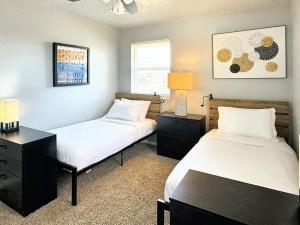 俄克拉何马城Clean, Comfortable & Modern Near Downtown Sw79的一间卧室配有两张床和一张带台灯的书桌。