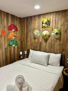 岘港Rom Casa Hostel Da Nang的一间卧室配有一张床和带遮阳伞的木墙