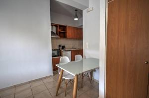 帕莱欧卡斯提撒Astacos Studios的小厨房配有白色的桌子和椅子