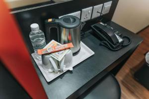 新加坡Hotel 81 Heritage的配有咖啡壶的柜台和一瓶水