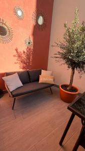 波尔图Coruja’s House AL OPO的带沙发和盆栽树的客厅